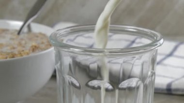 Bir kase kahvaltılık gevreğin yanına süt dökmek.