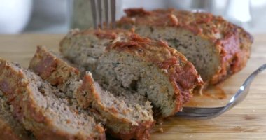 Kesme tahtasından taze fırınlanmış bir rulo köfteyi çıkarıyorum.