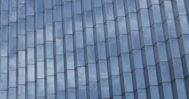 Gökyüzü ve bulutlar modern cam gökdelenlerin camlarına yansıyor.