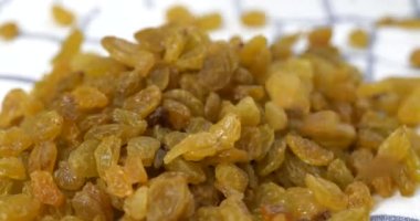 Altın kuru üzümler mutfak havlusuna düşüyor.