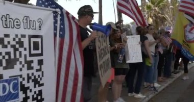 Santa Monica, CA USA - 29 Ağustos 2021: İnsanlar Ocean Drive 'da aşı talimatlarını ve pasaportları protesto eden pankartlarla sıraya diziliyor 