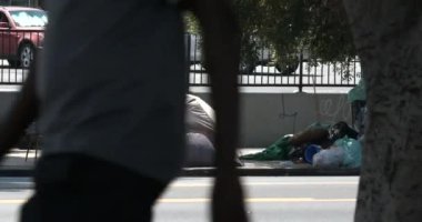 Los Angeles, CA USA - 24 Nisan 2021: Bir bakkal otoparkının önündeki evsiz kampı