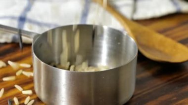 Yasemin pirincini paslanmaz çelik ölçü kabına döküyorum.