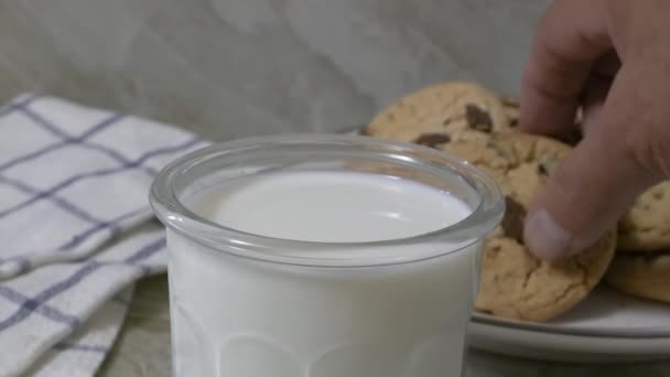 Aus Nächster Nähe Einen Schokoladenkeks Ein Glas Milch Werfen — Stockvideo