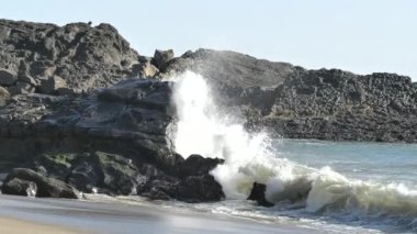 Dalgalar kıyıda kayalara çarpıyor. Süper yavaş çekimde.