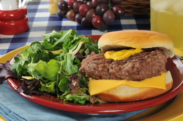 Cheeseburger und Salat — Stockfoto