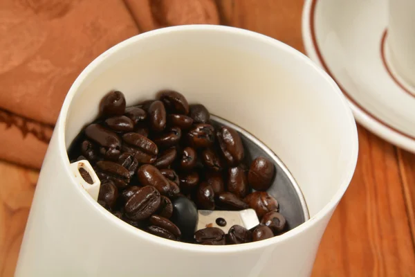 Кофейные зерна в кофемолке — стоковое фото