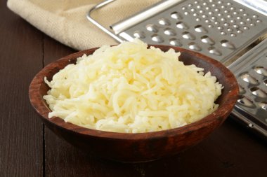Wooden bowl of grated swiss clipart