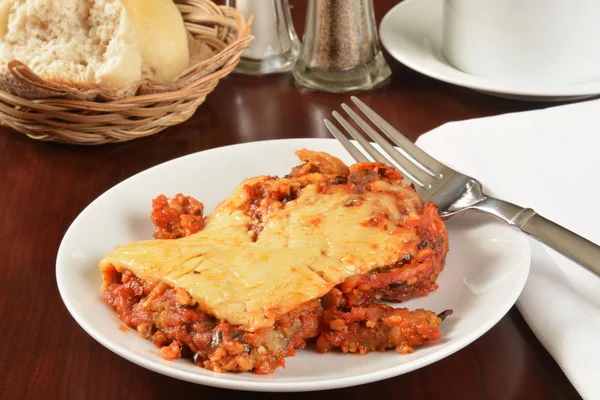 Eggplant parmesan with dinner rolls — Stock Photo, Image