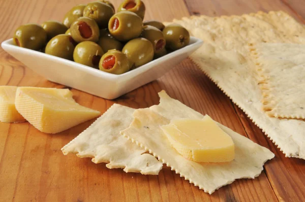 Käse mit Crackern und Oliven — Stockfoto