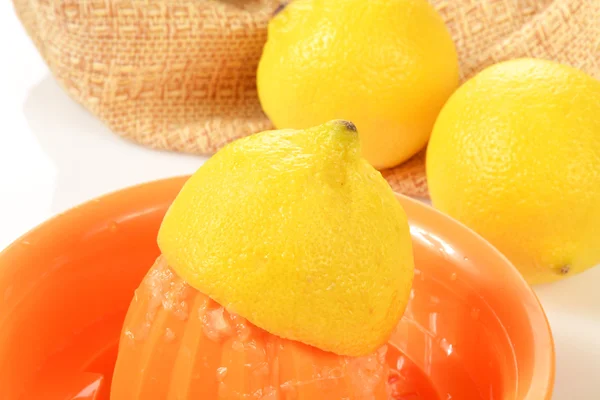 Лимон, будучи juiced на соковижималка — стокове фото