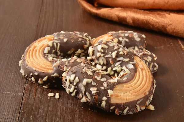 Cookies dipped in chocolate and sprinkled with nuts — Stock Photo, Image