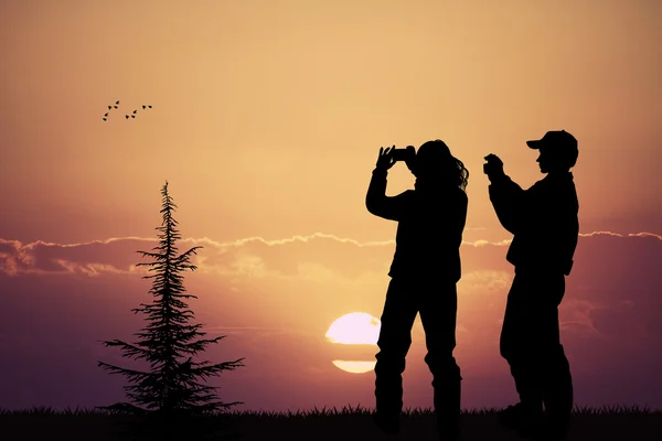 Люди фотографируют закат с помощью мобильного телефона — стоковое фото
