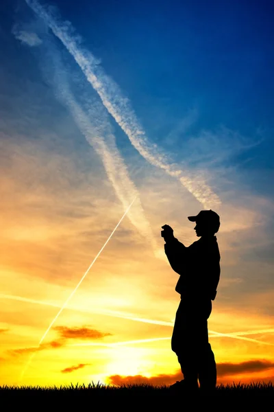 Çocuk kendi cep telefonu ile gün batımında fotoğraf yapar — Stok fotoğraf