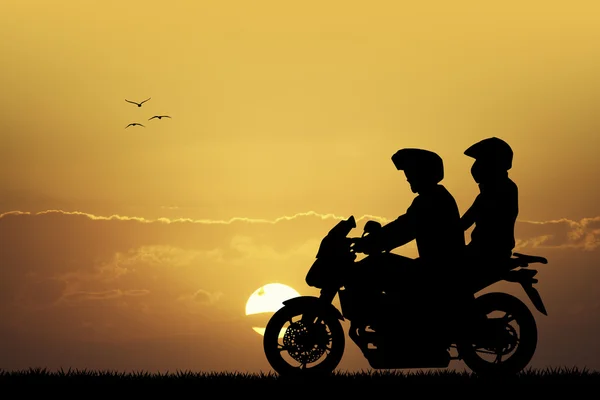 Couple on motorcycle at sunset — Stock Photo, Image