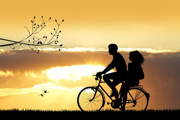 Couple on bicycle at sunset — Stock Photo, Image