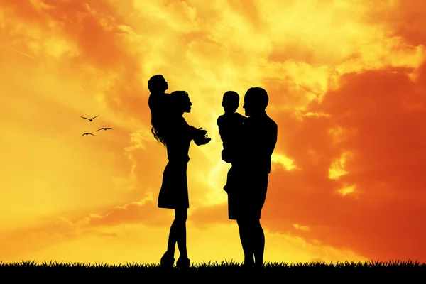 Батьки з дітьми на заході сонця — стокове фото