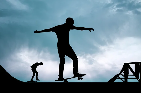 Pojkar med skateboard i solnedgången — Stockfoto