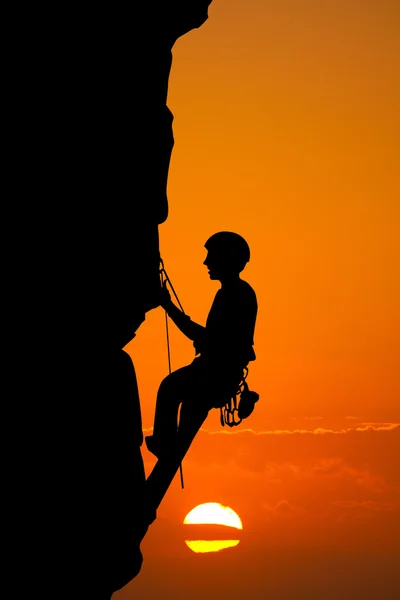 Homem sobe montanha ao pôr do sol — Fotografia de Stock