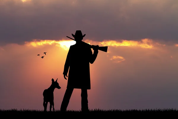 Hunter z psem na zachodzie słońca — Zdjęcie stockowe
