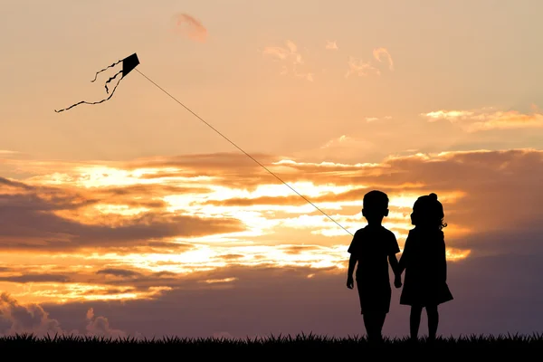 Crianças com pipa ao pôr do sol — Fotografia de Stock