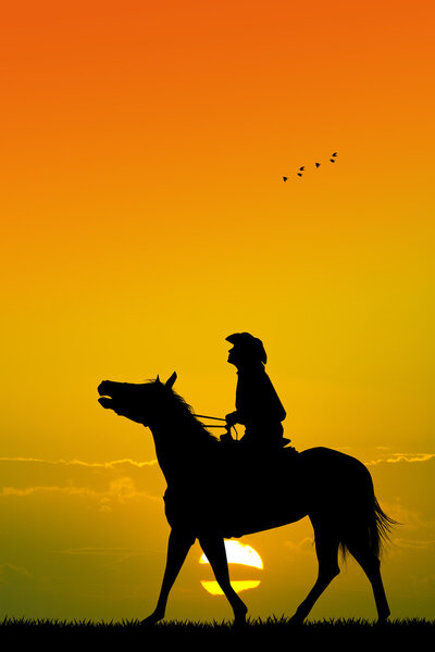cowboy on horseback at sunset
