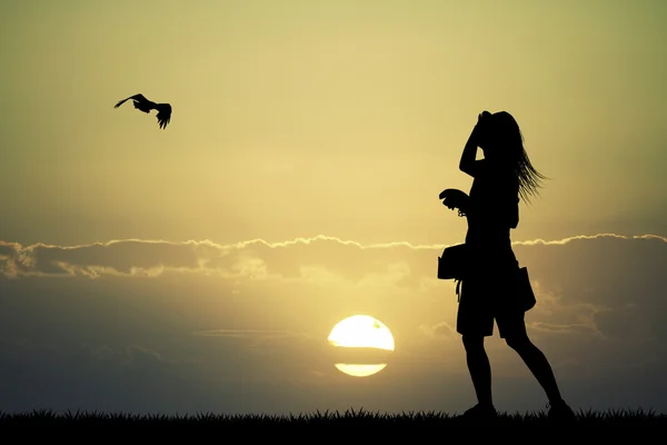 Girl with hawk at sunset — Stock Photo, Image