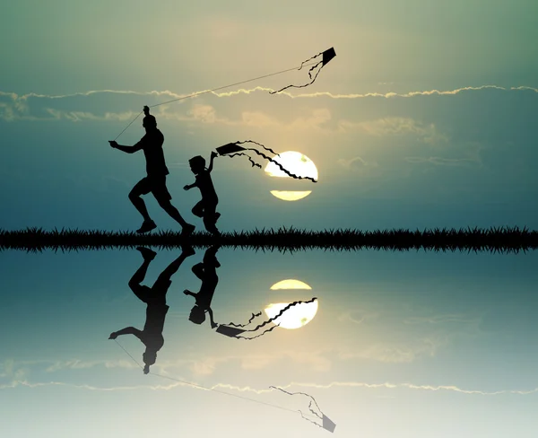 Père et fils avec cerf-volant au coucher du soleil — Photo