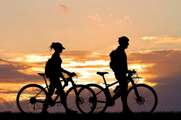 Pareja con bicicleta al atardecer — Foto de Stock