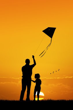 Baba ve oğul gün batımında uçurtma ile