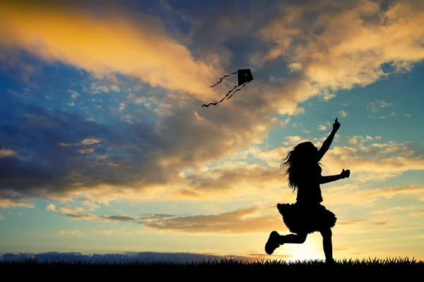 Fille avec cerf-volant au coucher du soleil — Photo