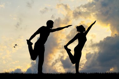gün batımında yoga yaparken çift