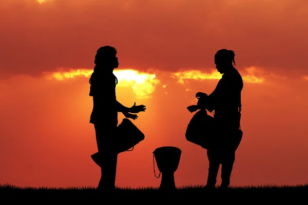 Afryki ludzi gra na bębnie o zachodzie słońca — Zdjęcie stockowe