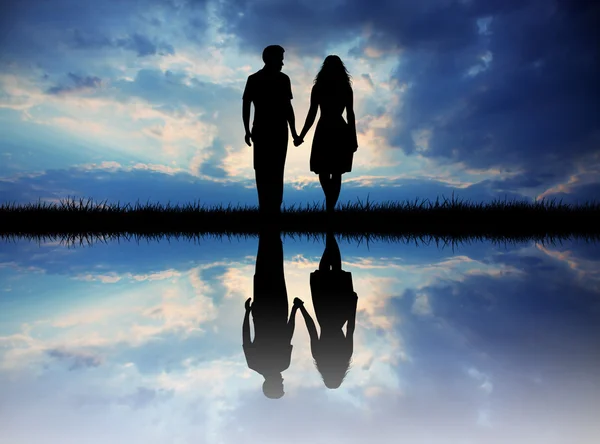 Couple silhouette on river at sunset — Stock Photo, Image