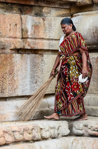 Индийская женщина в национальной одежде носит метлу — стоковое фото