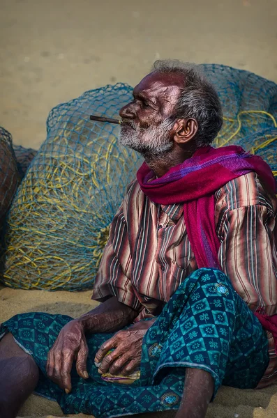 Unidentified old fisherman smoking on Marina beach — Stock Photo, Image