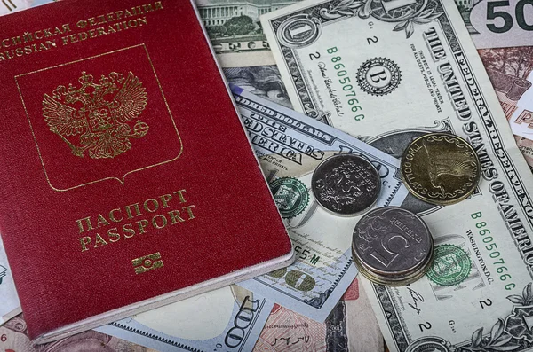O passaporte russo em uma pilha de moedas estrangeiras — Fotografia de Stock