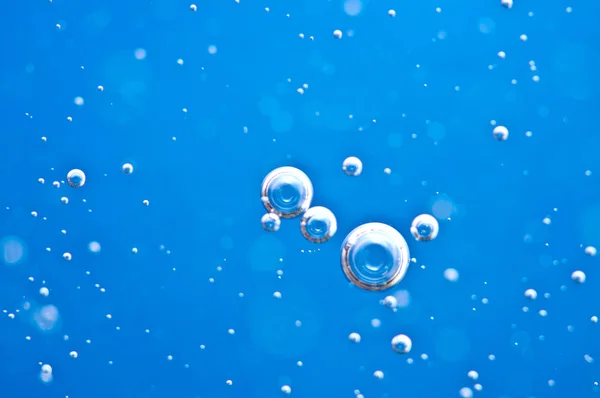 Close-up bubbles under water on blue background. Macro. — Stock Photo, Image