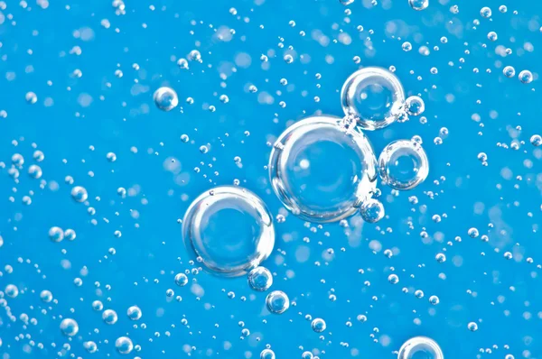 Burbujas brillantes bajo el agua sobre fondo azul. Macro . —  Fotos de Stock