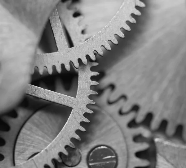 Fondo blanco negro con ruedas dentadas de metal un reloj. Macro — Foto de Stock