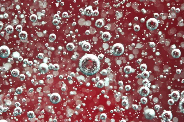 Luftblasen im roten Wasser. Makro — Stockfoto