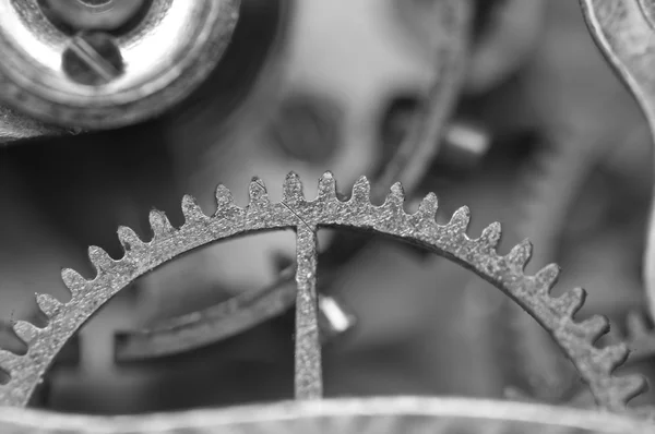 Fondo blanco negro con ruedas dentadas de metal un viejo reloj . — Foto de Stock