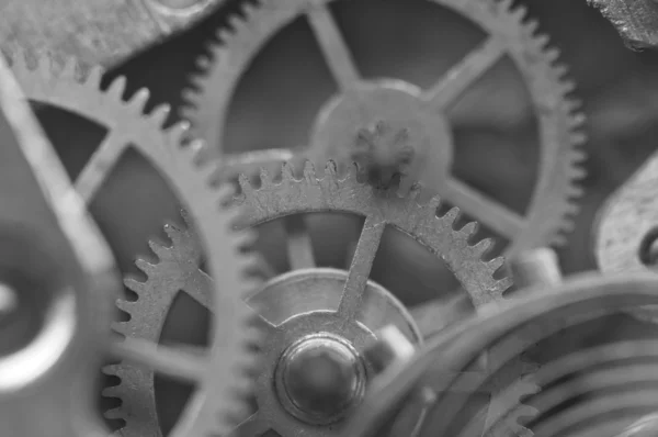 Черно-белый фон с металлическими зубчатыми колесами внутри часов — стоковое фото