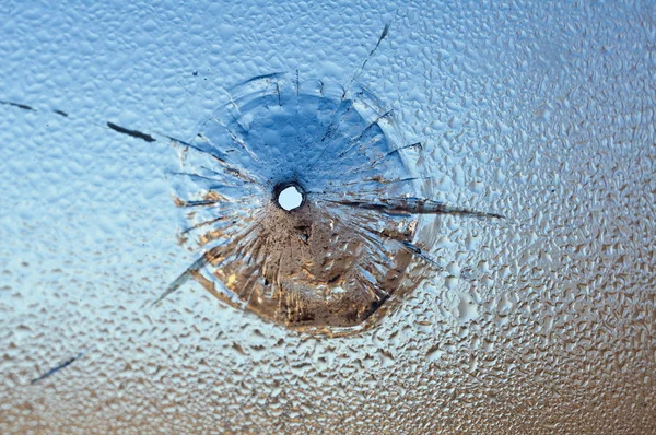 Einschussöffnung im nassen Glas, zerbrochenes Glas. — Stockfoto