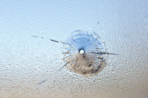 Střela otvor v mokrém skle, rozbité sklo. — Stock fotografie