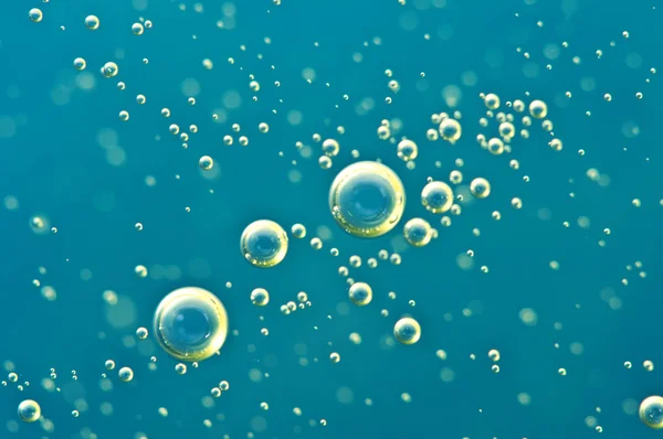 Macro Oxygen bubbles in water on blue background — Stock Photo, Image