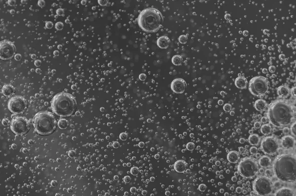 Macro Oxygen bubbles in water on black-and-white background — Stock Photo, Image