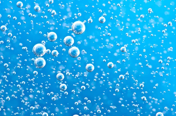Burbujas de oxígeno macro en agua clara azul — Foto de Stock