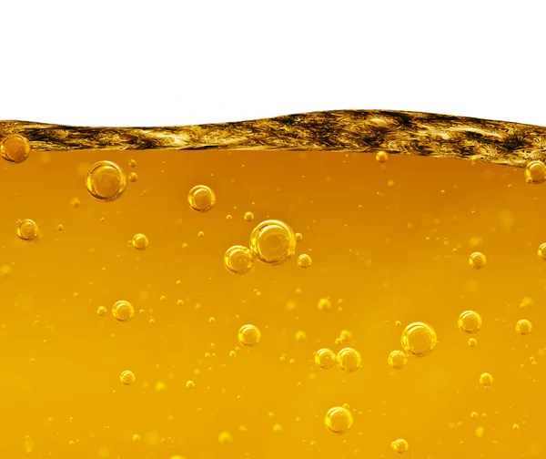 Welle einer gelben Flüssigkeit mit Luftblasen auf weißem Hintergrund — Stockfoto