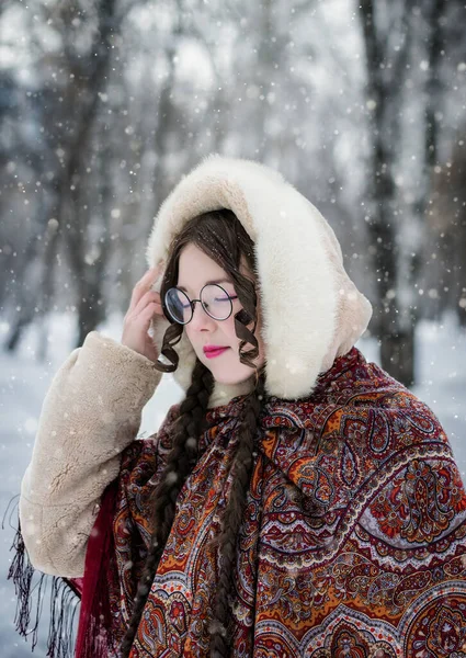 寒い冬の日に森の中の雪の公園で笑顔を見せる女性 — ストック写真
